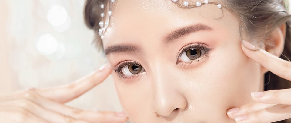 진주 헤어핀을 한 여성 모델이 양손 검지로 눈꼬리와 광대를 짚고 정면을 응시한 눈매 클로즈업
