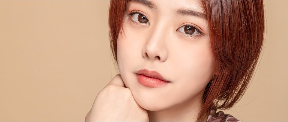단발 헤어의 여성 모델이 손으로 턱을 받치고 카메라를 바라보는 상반신 사진