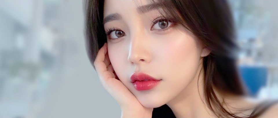 한 손으로 턱을 받치고 정면을 바라보는 여성의 또렷한 눈매 클로즈업