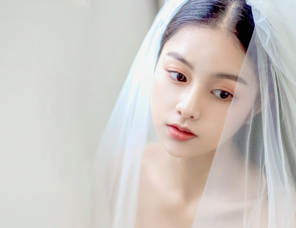 흰색 튤 면사포를 쓴 신부 모델의 얼굴과 어깨 클로즈업