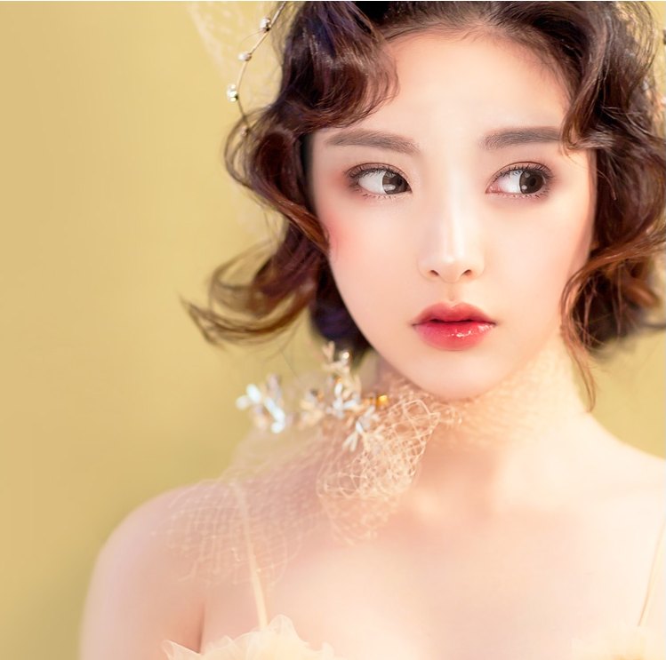 진주 헤어피스와 튤 망사 초커를 한 웨딩 스타일 여성 모델의 상반신 사진